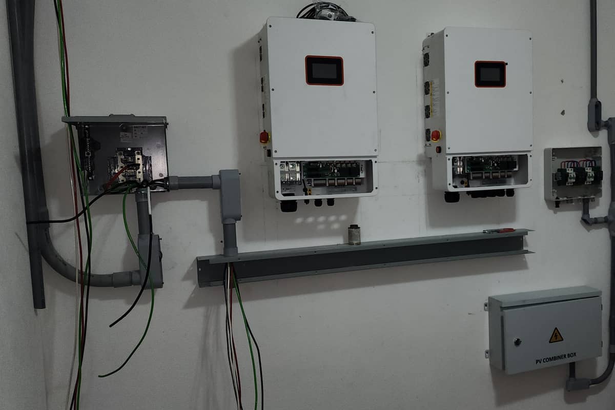 Neatly installed power electronics and combiner box in a plant room